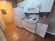 Kitchen boasts essential appliances, wood-style floors, white cabinets, and an above-range microwave at 36137 Lake Chase Blvd # 102, Zephyrhills, FL 33541