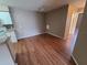 Open-concept living room with wood flooring and white trim and leads into the kitchen area at 36137 Lake Chase Blvd # 102, Zephyrhills, FL 33541