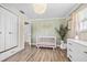 Bedroom with white crib, dresser, and hardwood floors illuminated by soft, natural light at 400 53Rd N St, St Petersburg, FL 33710