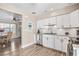 A modern kitchen with stainless steel appliances, white cabinets, and an open layout leading to the dining area at 400 53Rd N St, St Petersburg, FL 33710