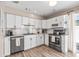 A bright and modern kitchen featuring stainless steel appliances, white cabinets, and stylish backsplash at 400 53Rd N St, St Petersburg, FL 33710