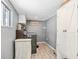 Well-organized laundry room with gray paint, gray flooring, storage cabinet, and new washer and dryer at 400 53Rd N St, St Petersburg, FL 33710