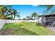Spacious backyard featuring lush green grass, white fence, and mature trees, perfect for outdoor activities at 4112 W Lawn Ave, Tampa, FL 33611
