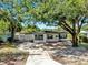 Charming single-story home with mature trees, black trim windows and a well-manicured front yard at 4112 W Lawn Ave, Tampa, FL 33611