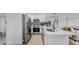 Modern kitchen with white cabinetry, stainless steel appliances and an island, open to the living room at 4112 W Lawn Ave, Tampa, FL 33611