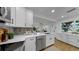 Stylish kitchen featuring stainless steel appliances, quartz countertops, and views of the adjacent living area at 4112 W Lawn Ave, Tampa, FL 33611