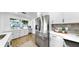 Modern kitchen boasts stainless steel appliances, white cabinets, quartz countertops and a breakfast bar at 4112 W Lawn Ave, Tampa, FL 33611