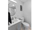 Bright bathroom features a round mirror over gray vanity and toilet at 4460 67Th N St, St Petersburg, FL 33709
