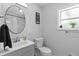 Cozy bathroom featuring a round mirror, gray vanity, and a toilet at 4460 67Th N St, St Petersburg, FL 33709