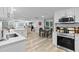 Bright, open kitchen featuring stainless steel appliances, light wood floors, and white cabinetry at 4460 67Th N St, St Petersburg, FL 33709