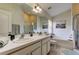 Bright bathroom featuring double sinks, a large mirror, and a separate shower and tub at 4522 Lisette Cir, Brooksville, FL 34604