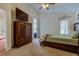 Comfortable bedroom with a ceiling fan, wood dresser, and natural light from the windows at 4522 Lisette Cir, Brooksville, FL 34604