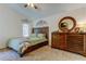 Comfortable bedroom with a ceiling fan, wood dresser, and natural light from the windows at 4522 Lisette Cir, Brooksville, FL 34604