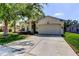 Home exterior featuring a two-car garage and a well-maintained front lawn and landscaping at 4522 Lisette Cir, Brooksville, FL 34604