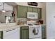 Well-equipped kitchen featuring a gas range, microwave, and stylish green cabinetry at 4522 Lisette Cir, Brooksville, FL 34604
