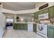 Bright kitchen boasts green cabinets, white appliances, and seamless access to the dining area, perfect for modern living at 4522 Lisette Cir, Brooksville, FL 34604
