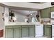 Bright kitchen with green cabinetry, countertops, modern appliances, and a pass-through to the living room at 4522 Lisette Cir, Brooksville, FL 34604
