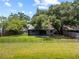 Aerial view of the backyard featuring a manicured lawn, privacy fencing, mature trees, and landscaping at 4639 Cabbage Palm Dr, Valrico, FL 33596