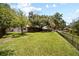 Spacious backyard with green grass, a wooded area, trees, and fencing at 4639 Cabbage Palm Dr, Valrico, FL 33596