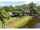 A serene backyard featuring a pond, grassy lawn, and a cozy screened porch, ideal for outdoor relaxation at 4639 Cabbage Palm Dr, Valrico, FL 33596