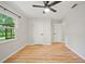 Bright bedroom featuring wood flooring, neutral wall paint, and a window offering plenty of natural light at 4639 Cabbage Palm Dr, Valrico, FL 33596