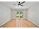 Bedroom with wood-look flooring, ceiling fan, and a window with views of the landscape at 4639 Cabbage Palm Dr, Valrico, FL 33596