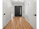 Inviting entryway featuring wood-look flooring, complemented by white trim and a stylish front door at 4639 Cabbage Palm Dr, Valrico, FL 33596