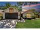 Charming home featuring a well-maintained lawn, a black garage door and neutral color scheme at 4639 Cabbage Palm Dr, Valrico, FL 33596