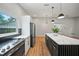 Modern kitchen with white cabinets, an island with a black base, and stainless steel appliances at 4639 Cabbage Palm Dr, Valrico, FL 33596