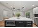 Kitchen island with a white countertop and black cabinetry, adjacent to an open living area at 4639 Cabbage Palm Dr, Valrico, FL 33596