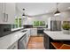 Bright kitchen featuring white cabinets, black backsplash, stainless appliances and a marble counter island at 4639 Cabbage Palm Dr, Valrico, FL 33596