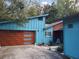 Modern, brightly colored home featuring a wood grain garage door with frosted glass windows at 5017 E 127Th Ave, Temple Terrace, FL 33617