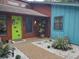 Stylish front entryway featuring a vibrant green door, modern landscaping, and a mix of textures at 5017 E 127Th Ave, Temple Terrace, FL 33617