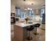 Modern kitchen with white cabinets, quartz countertops, stainless steel appliances, and island seating at 5017 E 127Th Ave, Temple Terrace, FL 33617