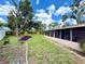 Expansive backyard with a lush lawn, large tree, privacy fence, and manicured landscape at 6285 52Nd N Ct, St Petersburg, FL 33709