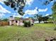 The property has a spacious backyard with a lush lawn, trees, and fence at 6285 52Nd N Ct, St Petersburg, FL 33709
