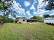 Spacious backyard featuring lush lawn, trees, and a screened patio at 6285 52Nd N Ct, St Petersburg, FL 33709