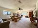 Spacious living room with a brick fireplace, a ceiling fan and two large windows at 6285 52Nd N Ct, St Petersburg, FL 33709