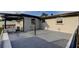 A view of a large gray back patio with a modern light fixture and exterior air conditioning unit at 7031 Magnolia Valley Dr, New Port Richey, FL 34653