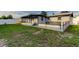 A backyard with a combination of a patio and grass with modern black fencing accents and white vinyl privacy fence at 7031 Magnolia Valley Dr, New Port Richey, FL 34653