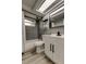 Bathroom features new modern vanity, stylish gray tile, and shower/tub combination at 7031 Magnolia Valley Dr, New Port Richey, FL 34653