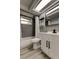 Bathroom boasts stylish gray tile, a modern vanity, and tub with a new shower and faucet at 7031 Magnolia Valley Dr, New Port Richey, FL 34653