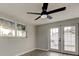 Bright bedroom with French doors and large windows, complemented by a modern ceiling fan at 7031 Magnolia Valley Dr, New Port Richey, FL 34653