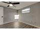 This bedroom features wood floors, neutral paint, one window and a ceiling fan with lighting at 7031 Magnolia Valley Dr, New Port Richey, FL 34653