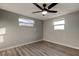 This bedroom features wood floors, neutral paint, two windows and a ceiling fan with lighting at 7031 Magnolia Valley Dr, New Port Richey, FL 34653