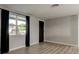 Empty room with wood flooring, black accents, and a large window with natural light at 7031 Magnolia Valley Dr, New Port Richey, FL 34653