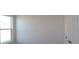 A bright bedroom features a window and a modern white door, offering a minimalist and clean aesthetic at 719 Allora Ave, Nokomis, FL 34275