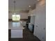 Modern kitchen with white cabinets, stainless steel appliances, and a large island with quartz countertops at 719 Allora Ave, Nokomis, FL 34275