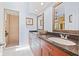 Bright bathroom with double sinks, granite countertops, framed mirrors, and walk-in shower at 751 Pinellas Bayway S # 104, St Petersburg, FL 33715