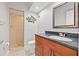 Nicely decorated bathroom with a walk-in shower and black-speckled countertop with wooden cabinetry at 751 Pinellas Bayway S # 104, St Petersburg, FL 33715